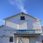 The old white barn at Tierra Vegetables rises against a clear blue sky.