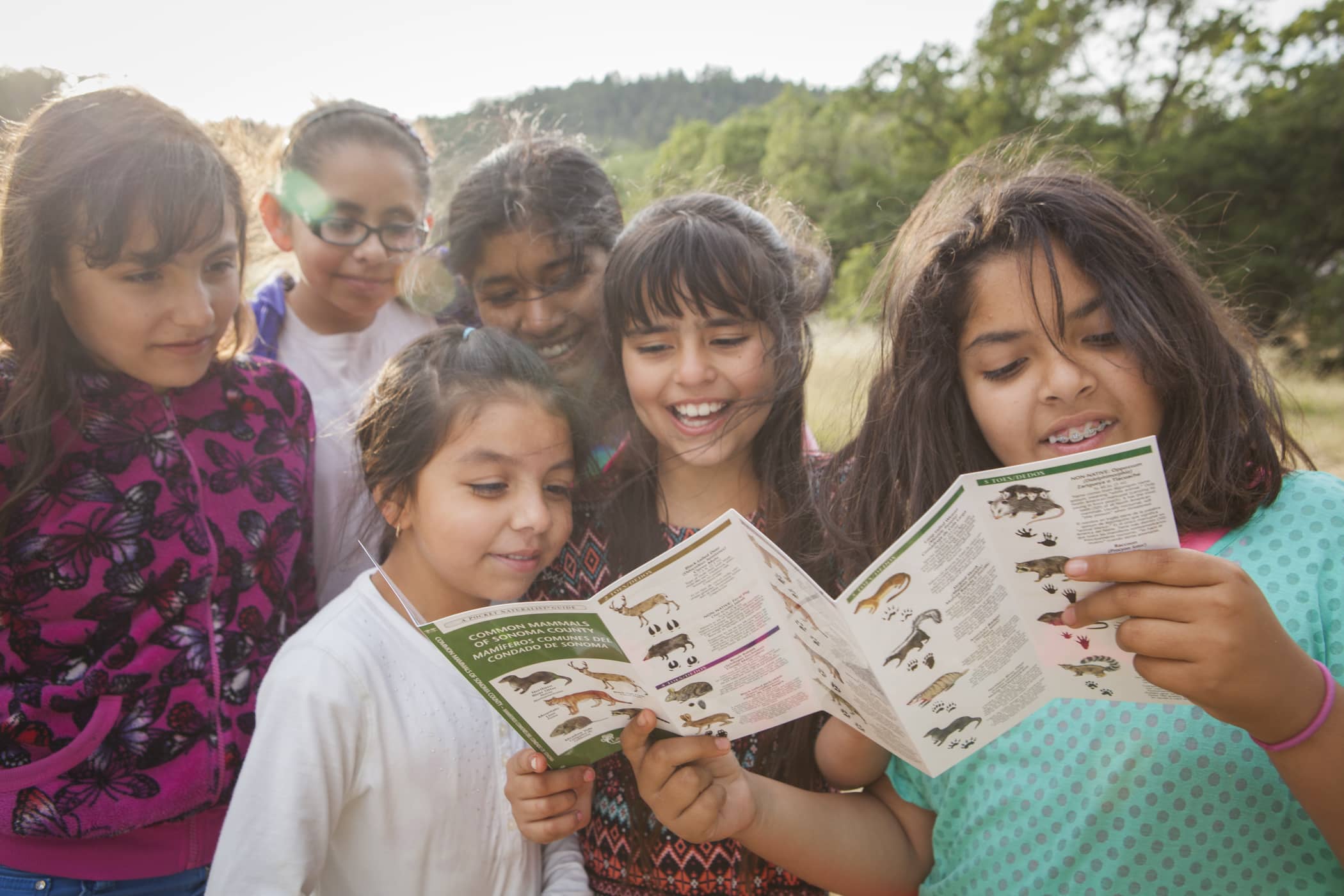 a group of young children looking at a paper