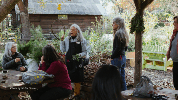 Instructors teach wreath making.