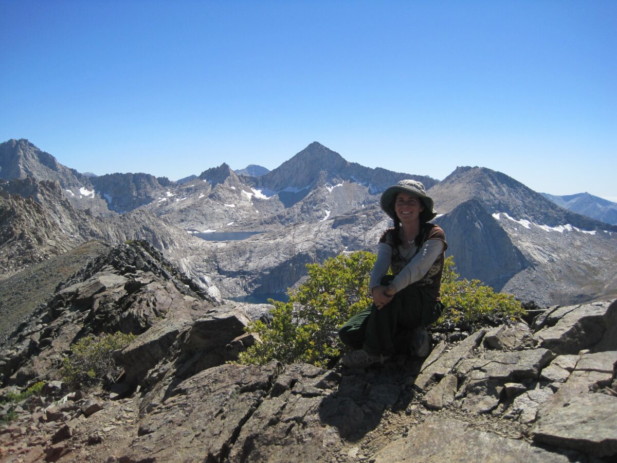 Monica sitting outside with mountains in the background