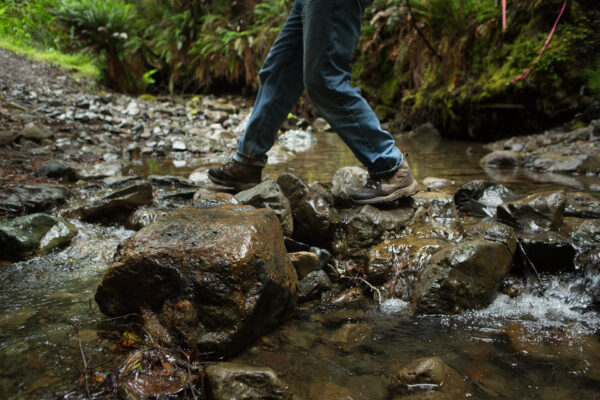 a person walking across rocks in the water