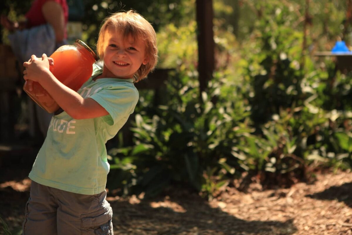 a young child holding a jar and smiling