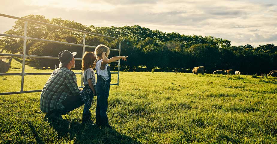 farmer and children pointing at cows