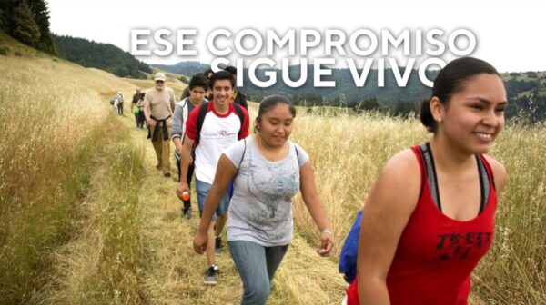 Hikers walk along a grassland trail