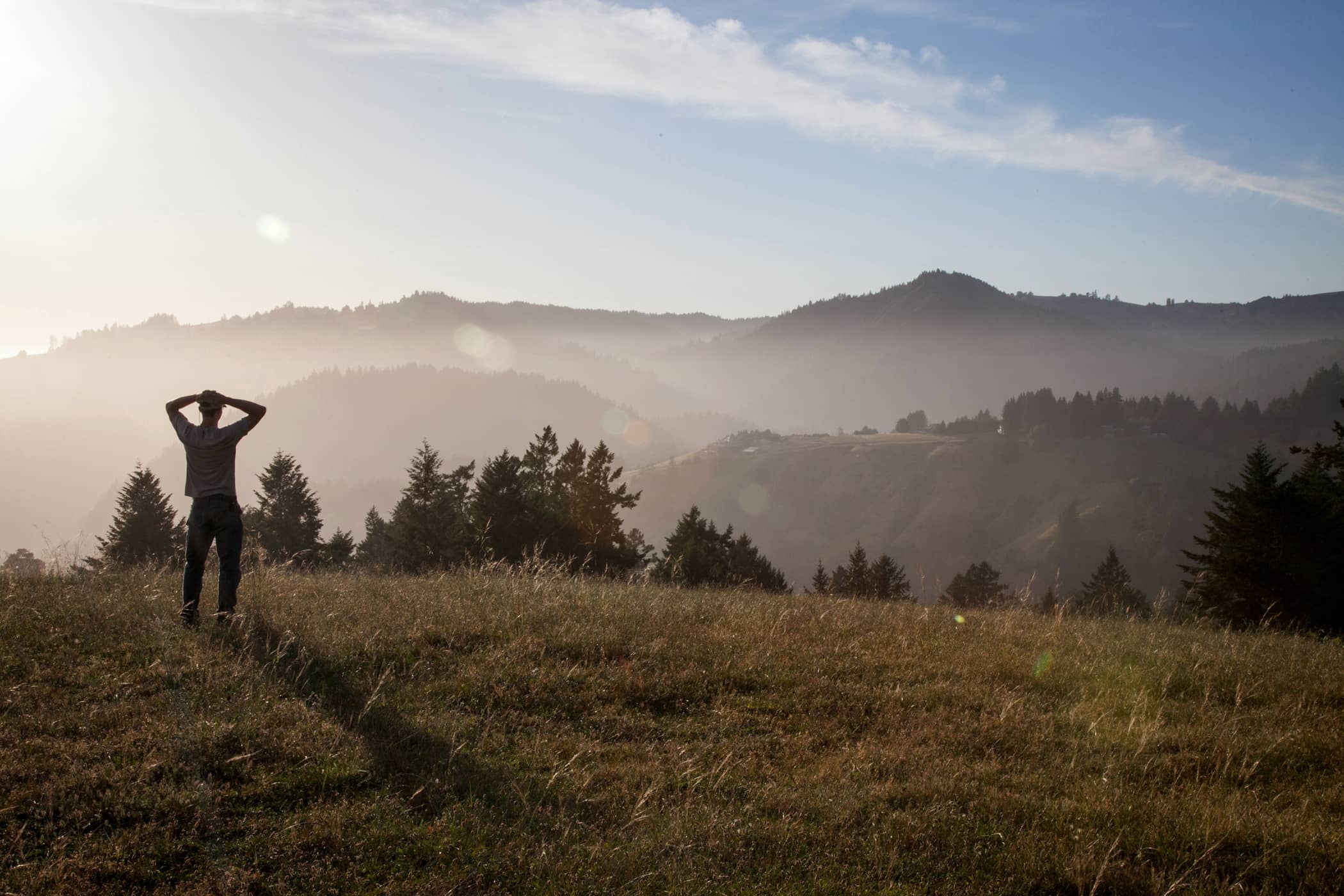 person standing with hands on head looking into distance